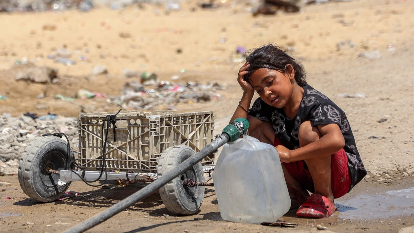 A girl fills containers with water drawn from the leftovers of underground pipes at a camp for people displaced by war in the Sheikh Radwan neighbourhood of Gaza City on 6 July 2026 (Omar al-Qattaa/AFP)