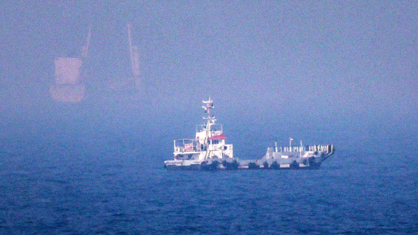 Ships at sea in hazy light near a narrow strait