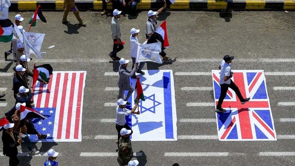 University students march with Palestinian and Yemeni flags over depictions of the Israeli, US and UK flags during a pro-Houthi demonstration at Sanaa University in Yemen's capital, 22 July 2026 (Mohammed Huwais/AFP)