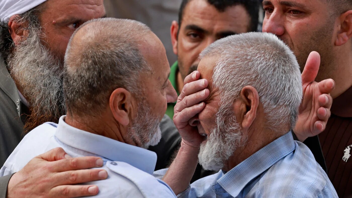 Family members of one of the four Palestinians killed by Israeli settlers weep outside a hospital in Nablus, in the occupied West Bank, on 24 July 2026 (Jaafar Ashtiyeh/AFP)