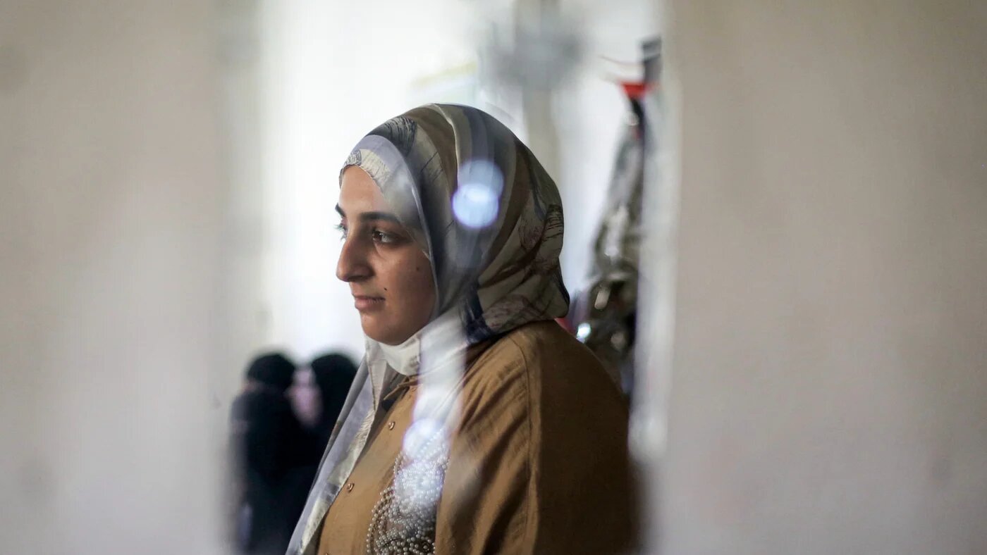 Palestinian highschool student Saba Rabah stands reflected through a broken mirror on a wall at the Maghazi camp for Palestinian refugees in the central Gaza Strip on 26July 2026 (Eyad Baba/AFP)