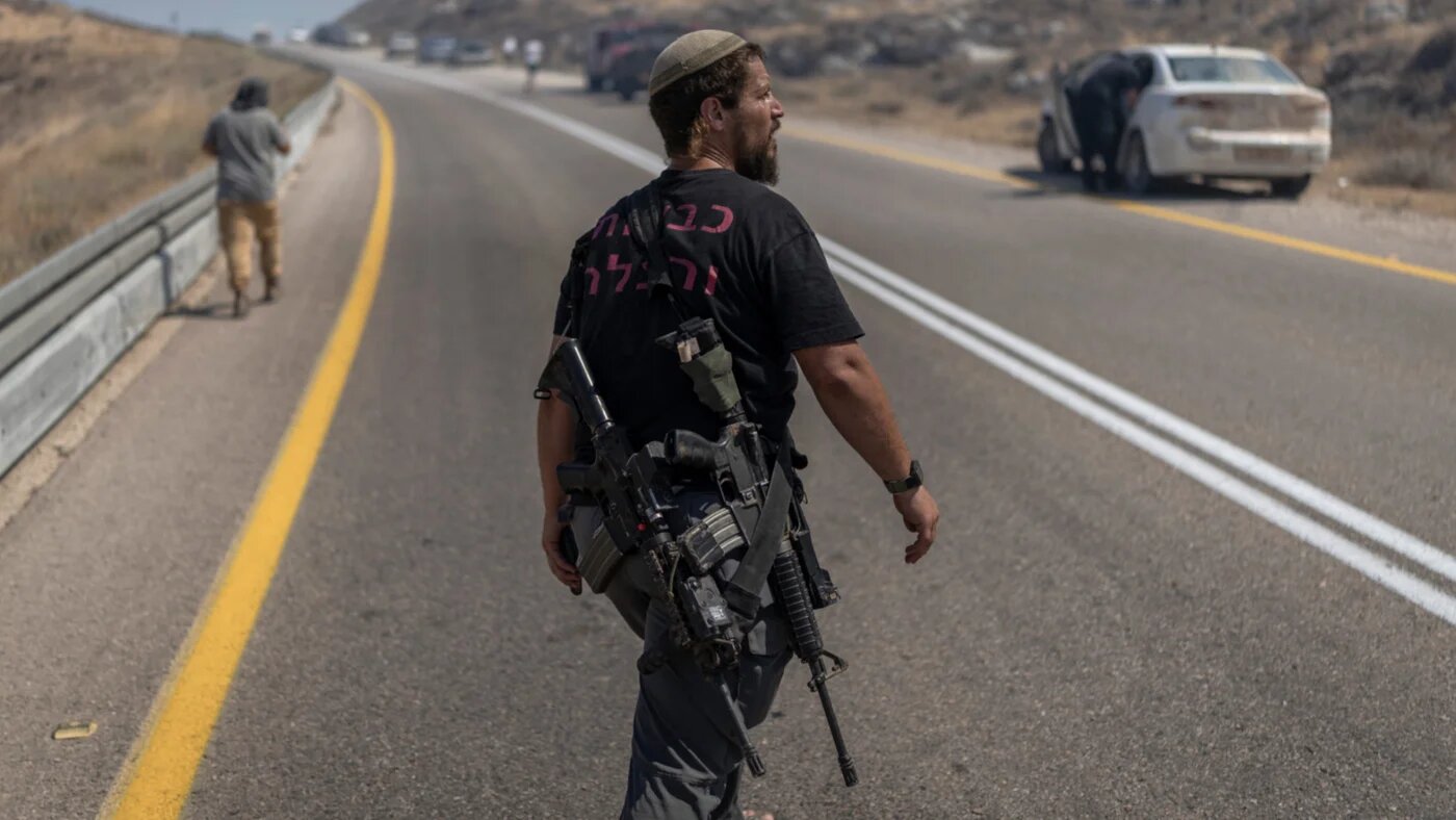An armed Israeli settler arrives at the site of a wildfire near the Ein Samiya spring in the occupied West Bank on 29 July 2026 (Ilia Yefimovich/AFP)