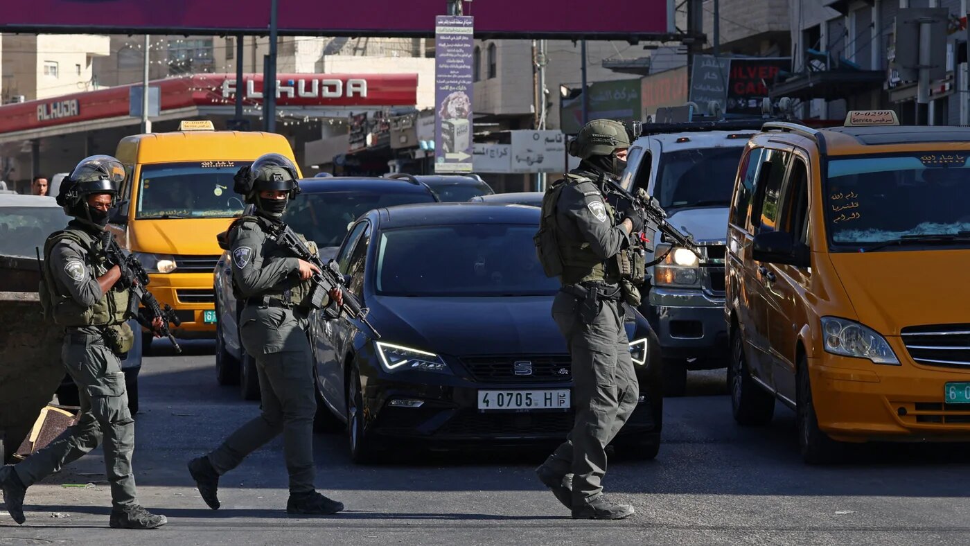 Israeli soldiers patrol along a busy street during a military raid in the Qalandia refugee camp, on 5 August 2026 (Zain Jaafar/AFP)