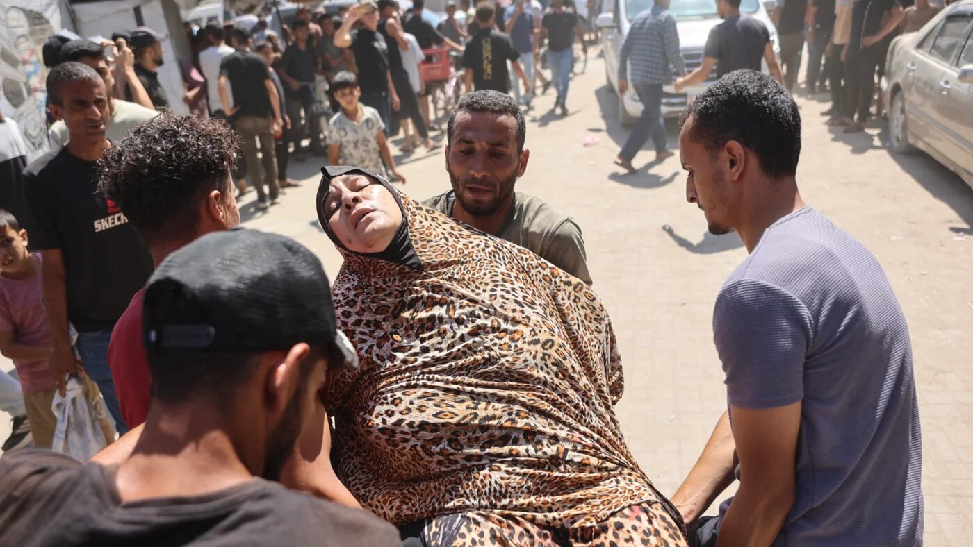 Palestinians carry a wounded woman away from the site of an Israeli strike that targeted the municipal police headquarters in Gaza City on 19 August 2026 (Omar al-Qattaa/AFP)