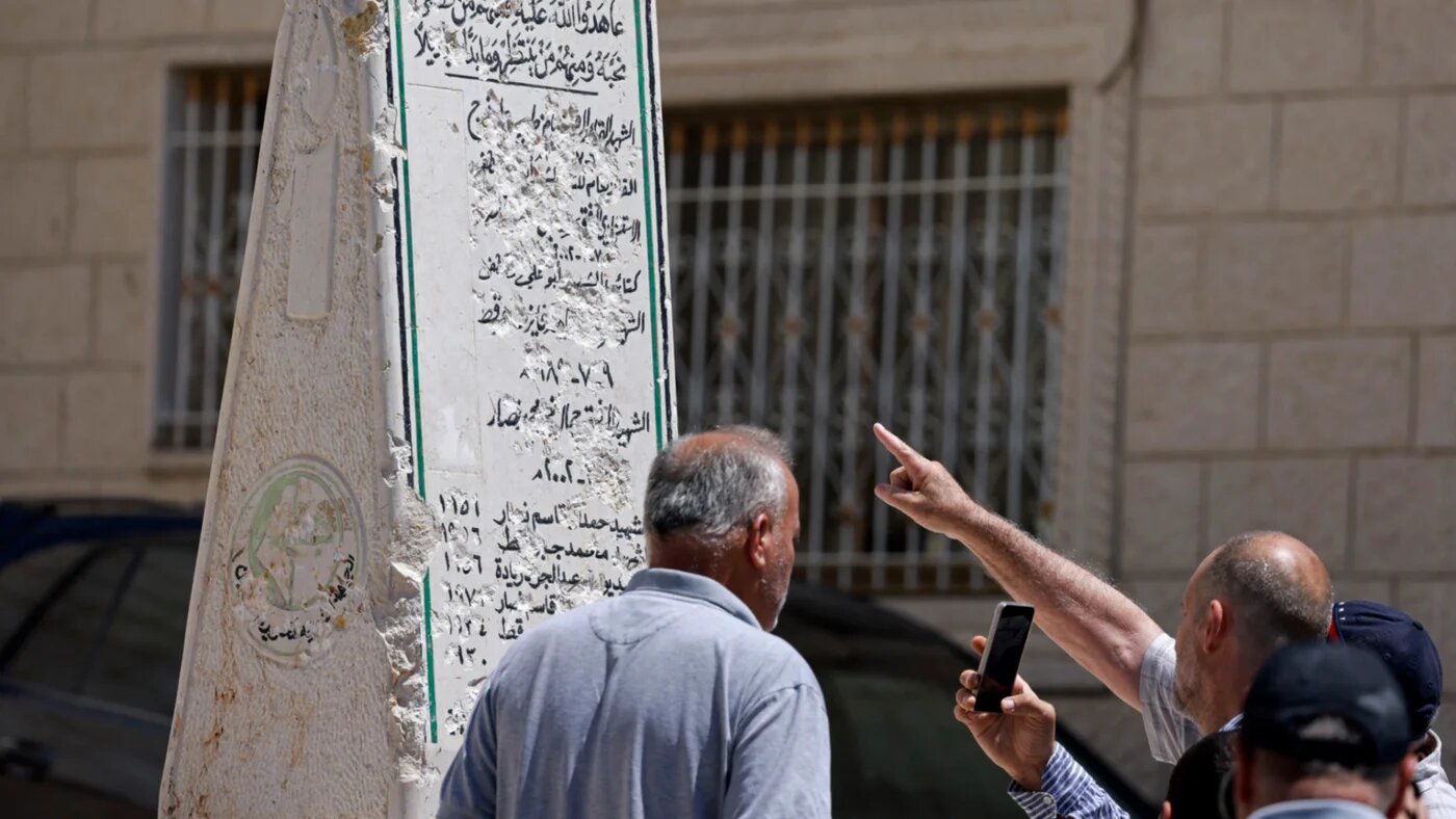 People inspect the damaged Palestinian memorial at the Madama village in the northern West Bank on 25 August 2026 (Jaafar Ashtiyeh/AFP)