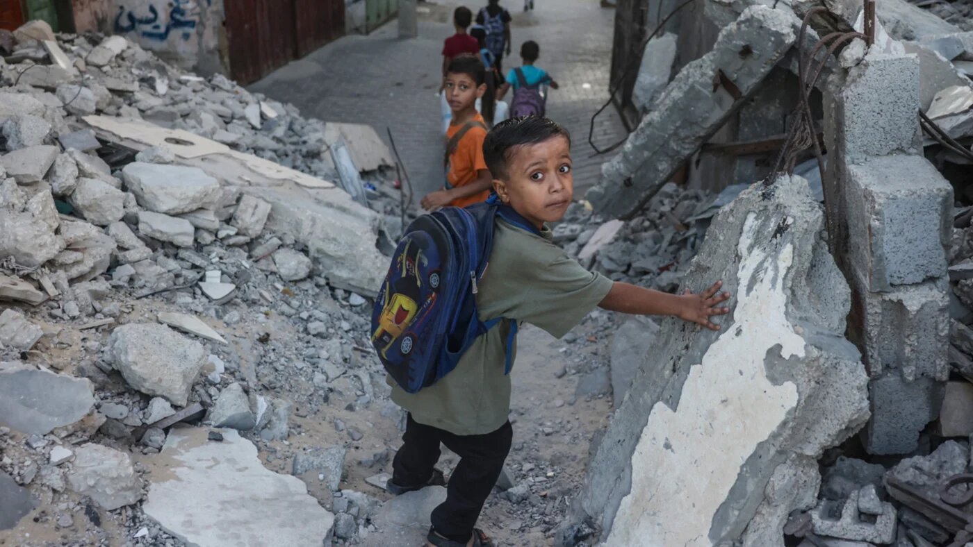 Palestinian children walk to school amid the rubble of destroyed buildings as the academic year begins, in Khan Yunis in the southern Gaza Strip, on 19 September 2026 (Bashar Taleb/AFP)