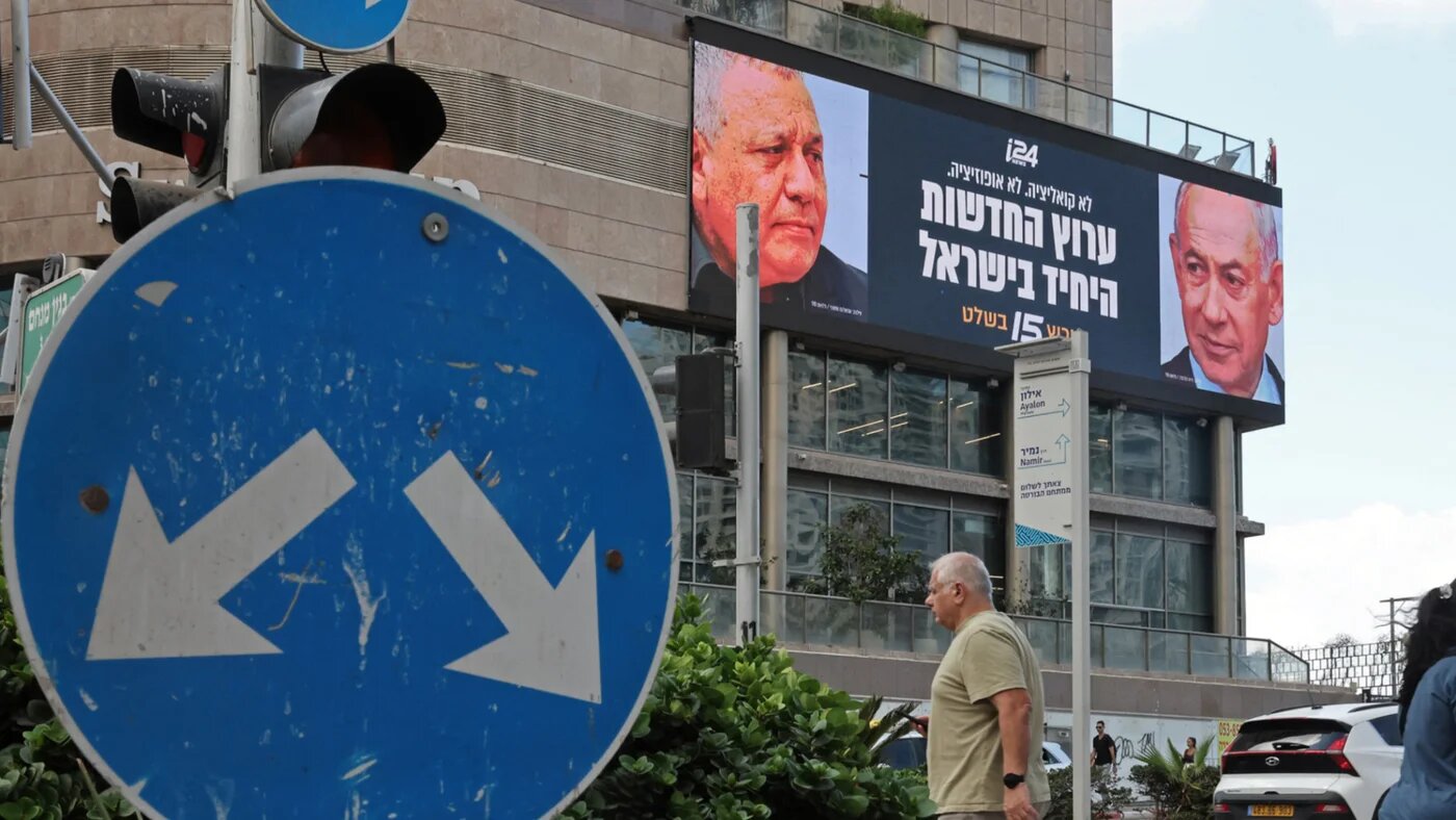 Pedestrians walk past an advertisement featuring Israel's Prime Minister Benjamin Netanyahu (R) of the Likud party and country's former chief of the general staff and leader of the Yashar party Gadi Eisenkot, along a street in Ramat Gan on 23 September 2026 (Jack Guez/AFP)