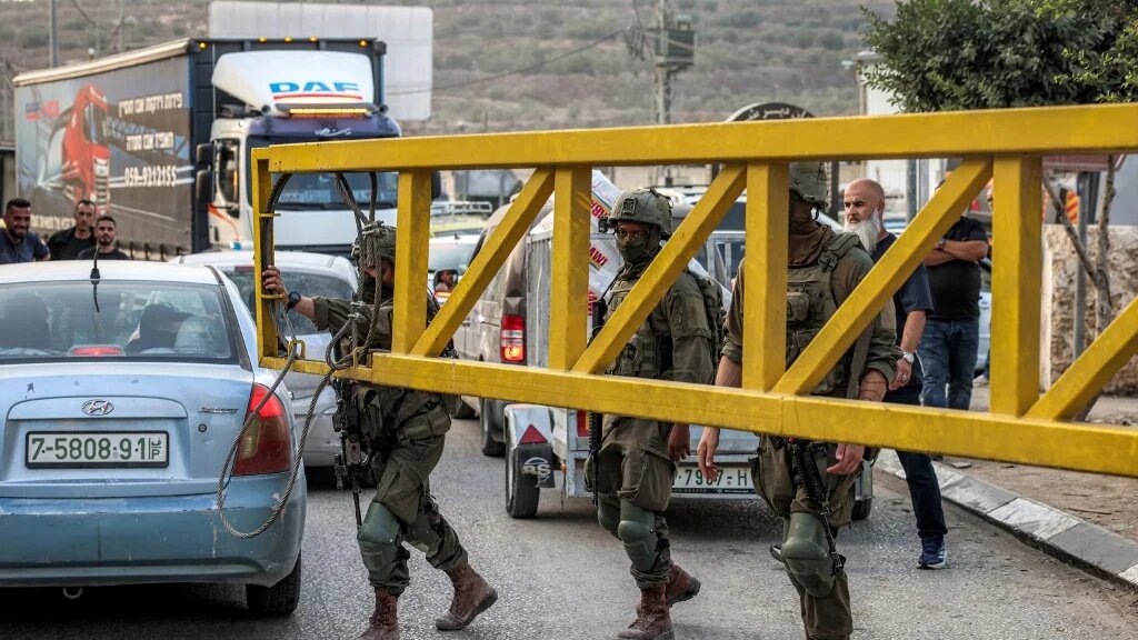 Israeli army soldiers close the vehicle barrier at the Deir Sharaf checkpoint, west of Nablus in the Israeli-occupied West Bank, on October 25, 2026. 