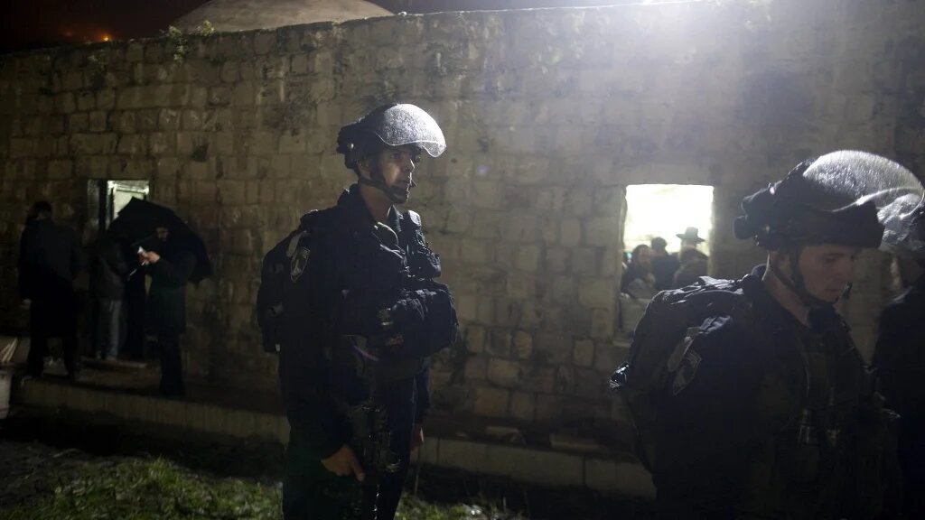 Israeli forces stand guard while Jews pray at Joseph's Tomb in the northern Palestinian West Bank city of Nablus on 16 February 2012. (AFP)