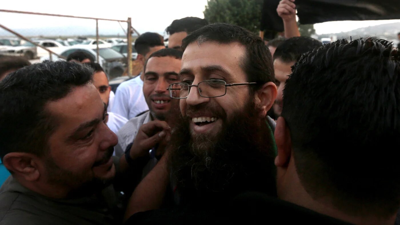 Khader Adnan greeted by friends and relatives as he arrives in the West Bank village of Arraba after his release from Israeli prison on 12 July 2015 (AFP)