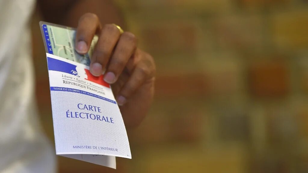 Une femme tient sa carte électorale dans un bureau de vote à Nantes, dans l’ouest de la France, lors du second tour des élections législatives françaises (élections législatives en français), le 18 juin 2017. (AFP/Loic Venance)