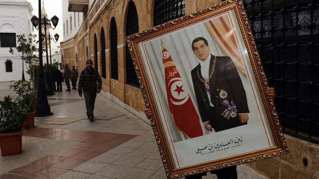 rois jours après la fuite de Ben Ali, un employé du Premier ministère à Tunis retire un portrait de l’ex-président déchu (AFP/Fethi Belaid)