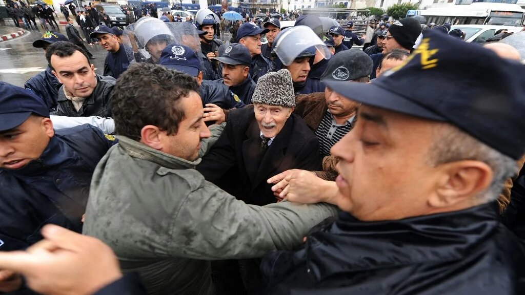 Ali Yahia Abdennour face aux forces de sécurité lors d’une manifestation à Alger, le 12 mars 2011 (AFP)