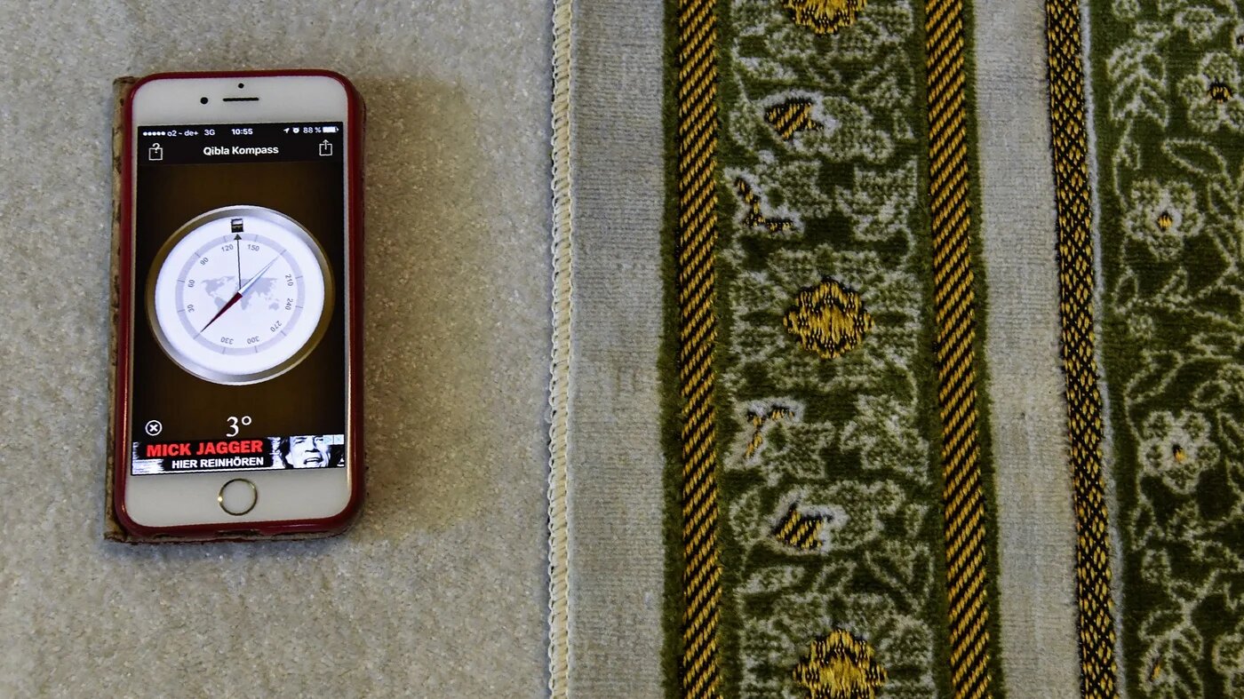 A compass app on a smartphone shows the prayer direction at the Ibn Rushd-Goethe-mosque in Berlin on 28 July 2017 (AFP/File photo)