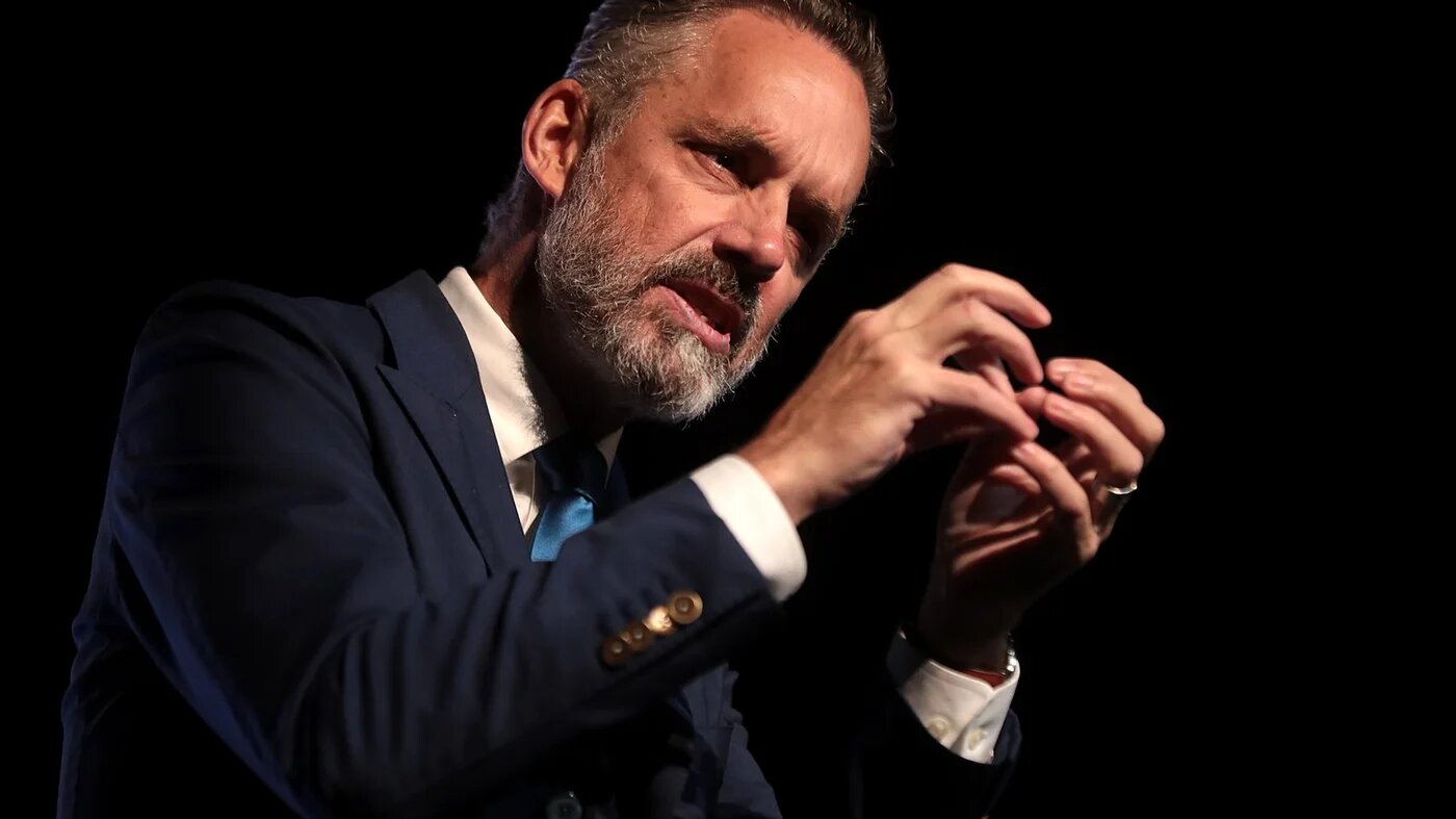 Jordan Peterson delivering a speech at a podium with a focused expression on his face. (Wikimedia Commons)