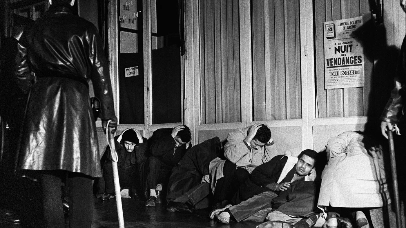 Des manifestants algériens appréhendés à Puteaux, à l’ouest de Paris, pendant la guerre d’Algérie, lors de la manifestation pacifique organisée à Paris le 17 octobre 1961 par la Fédération de France du FLN pour protester contre le couvre-feu imposé aux Français musulmans d’Algérie par le préfet de police Maurice Papon (AFP)
