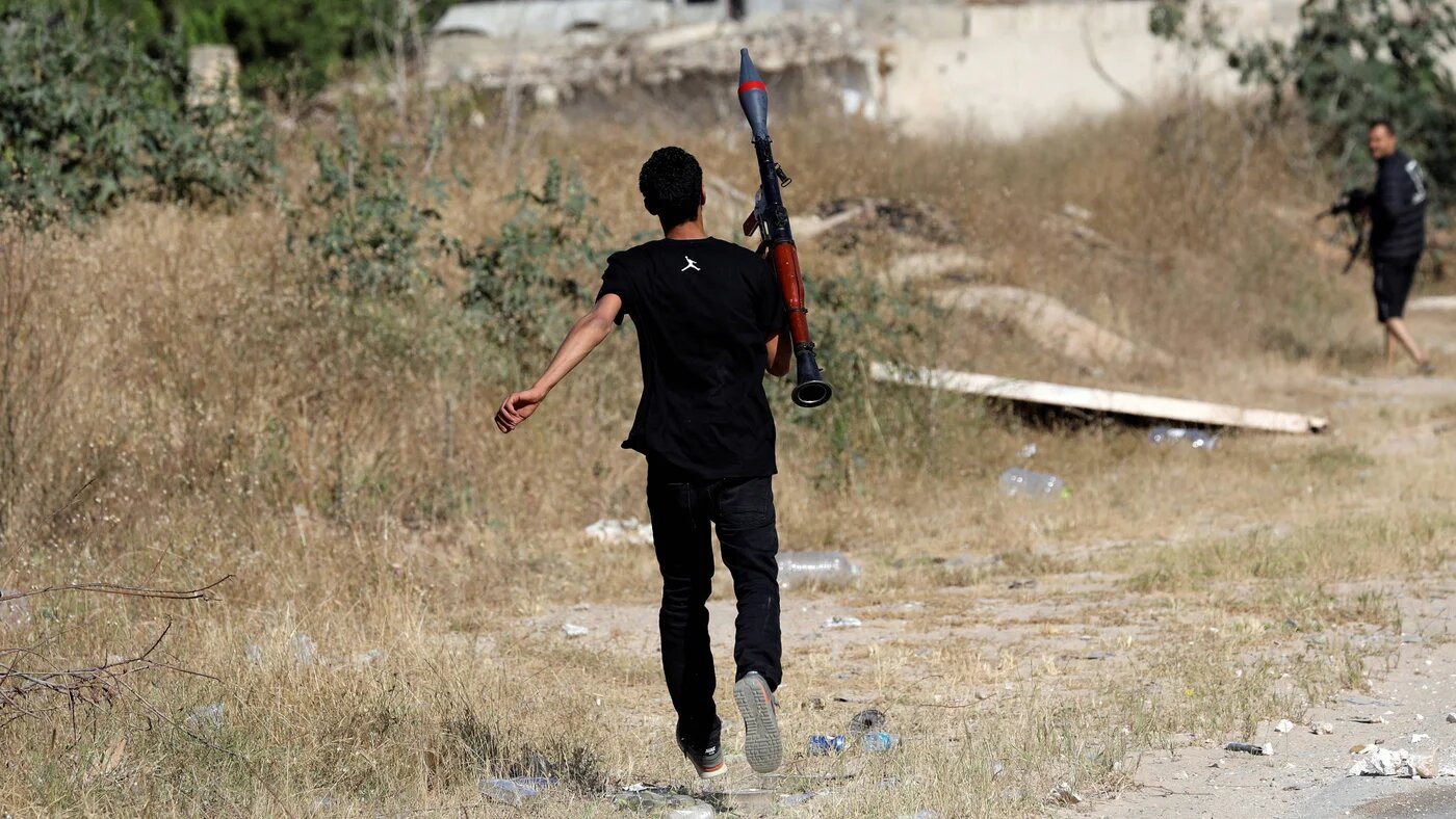 A Libyan fighter carries an RPG-7 during clashes between rival armed groups in al-Yarmouk south of Tripoli on 7 May 2019 (Reuters)