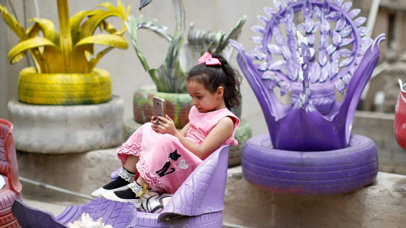 Young girl sits in a chair made from used tyres