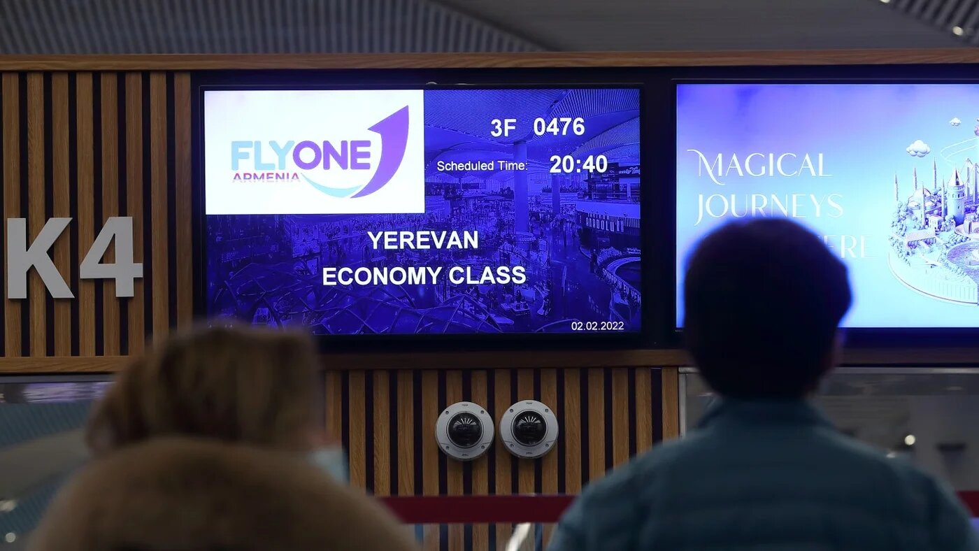 Passengers wait to check-in at the FlyOne Armenia counter for a flight from Istanbul to Yerevan at the Istanbul International Airport 2 February (Reuters)