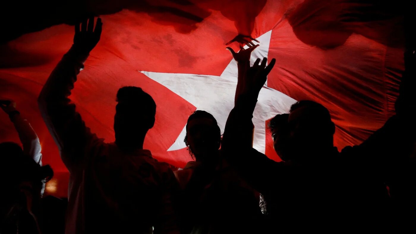 Supporters of Turkish President Recep Tayyip Erdogan react to early exit poll results for the second round of the presidential election, in Istanbul, on 28 May (Reuters)