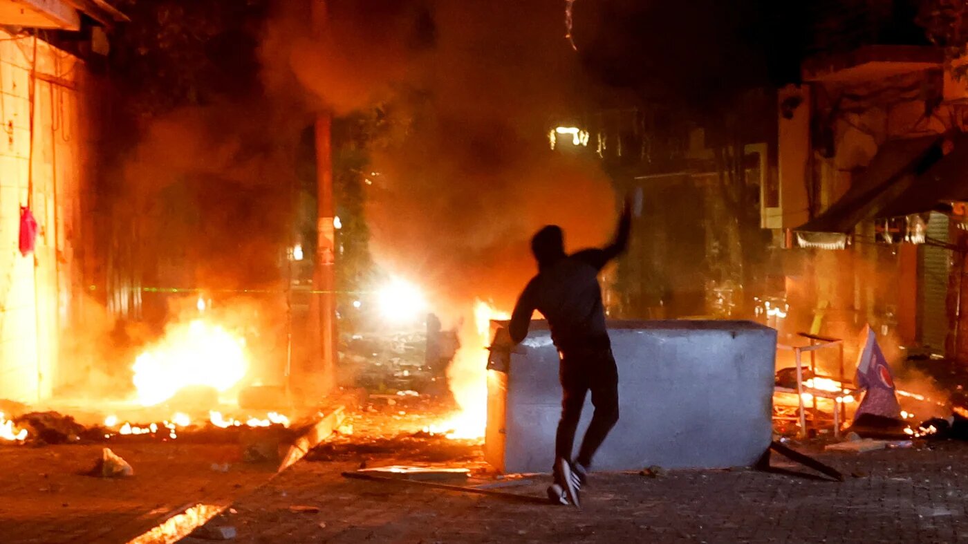 A Palestinian throws stones as the Israeli army raids Ramallah in theoccupied West Bank in 8 June 2023 (Reuters)