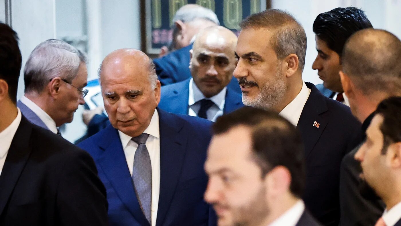 Turkey's Foreign Minister Hakan Fidan (R) and Iraq's Foreign Minister Fuad Hussein (L) leave after a meeting in Baghdad on 22 August 2023 (Reuters)
