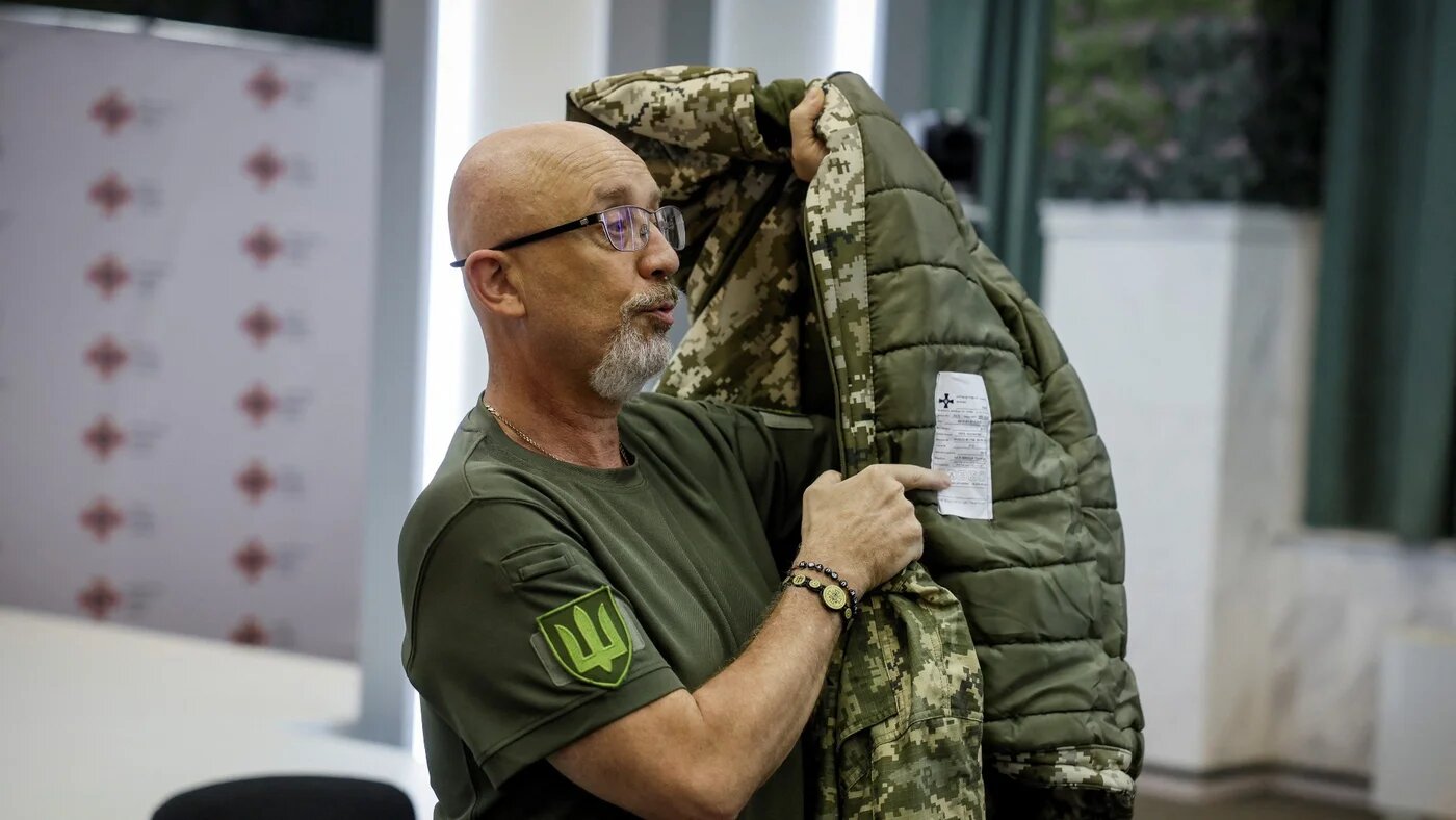Ukrainian Defence Minister Oleksiy Reznikov shows a military uniform during a news conference in Kyiv, 28 August (Reuters)
