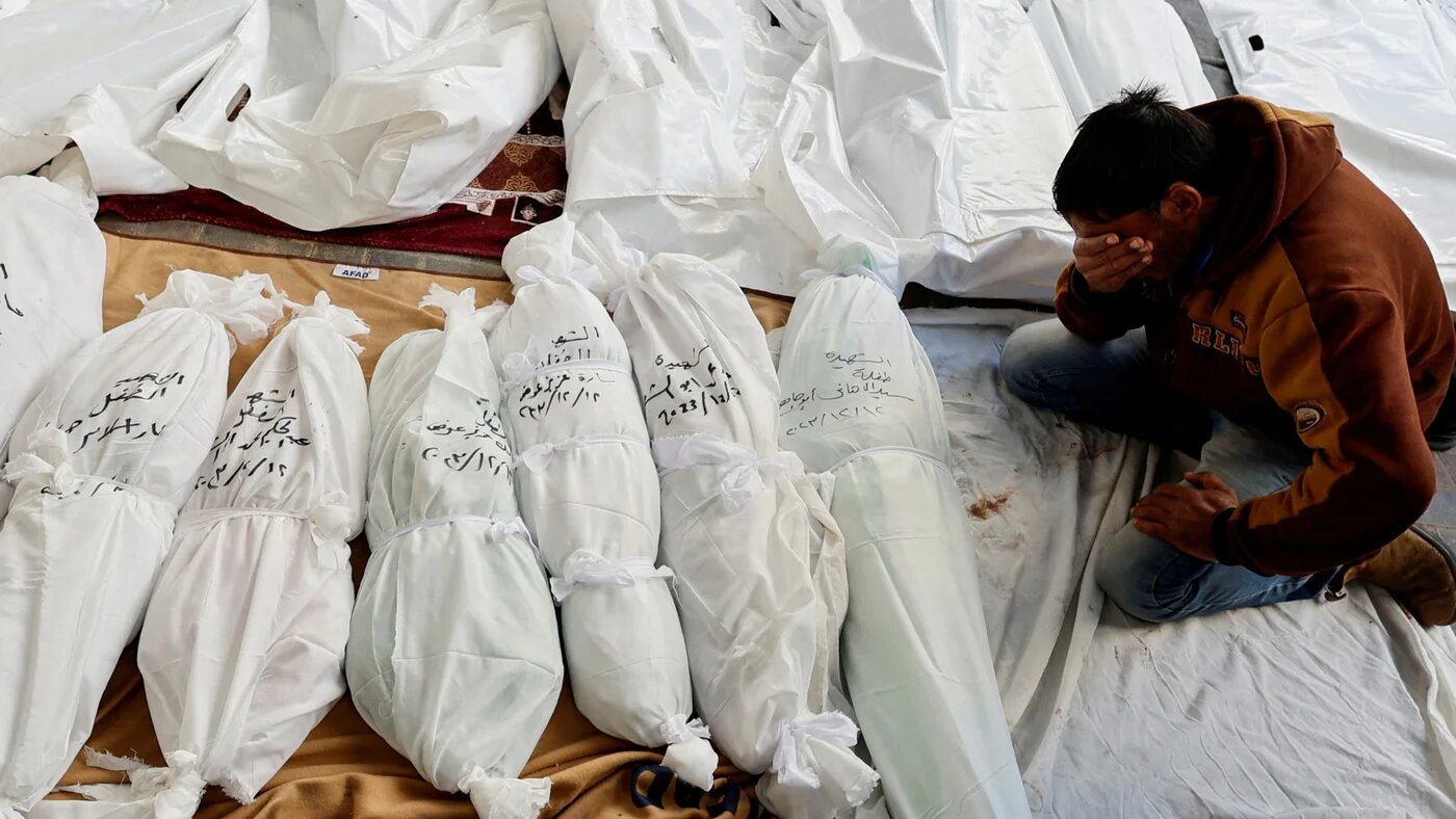 A mourner reacts next to the bodies of Palestinians killed in Israeli strikes at Abu Yossef Al-Najar hospital, in Rafah in the southern Gaza Strip 12 December 2023 (Reuters)