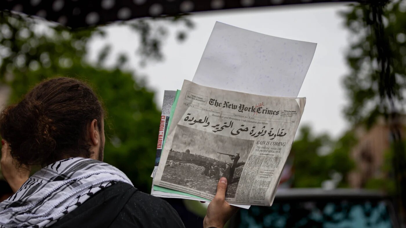 A pro-Palestinian demonstrator holds a mock edition of The New York Times at a rally marking the anniversary of the Nakba, on 18 May 2024 in New York City (Michael Nigro/Sipa USA)