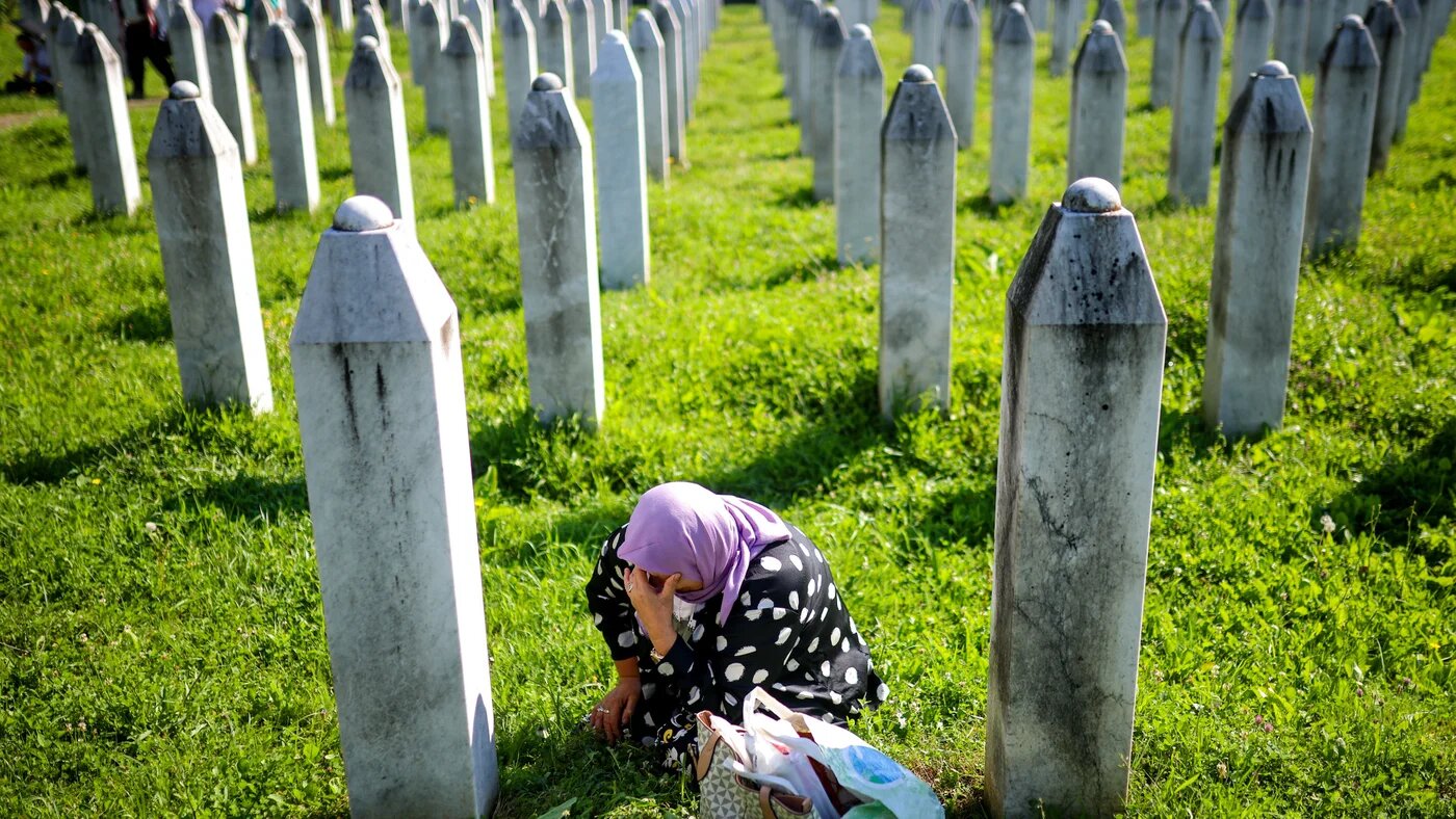 A Muslim woman prays at the grave of family members at the Potočari Genocide Memorial near Srebrenica on 11 July 2024, marking the 29th anniversary of the Bosnian genocide (Armin Durgut/Sipa USA)