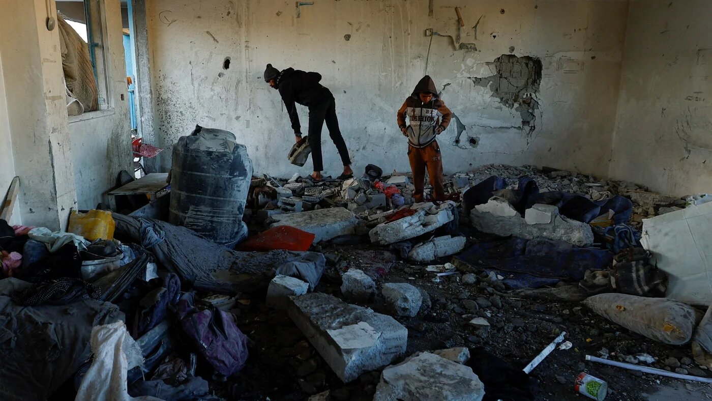 Palestinians inspect the damage in the aftermath of an Israeli strike on a school sheltering displaced people in Khan Younis in the southern Gaza Strip 16 December 2024 (Mohammed Salem/Reuters)