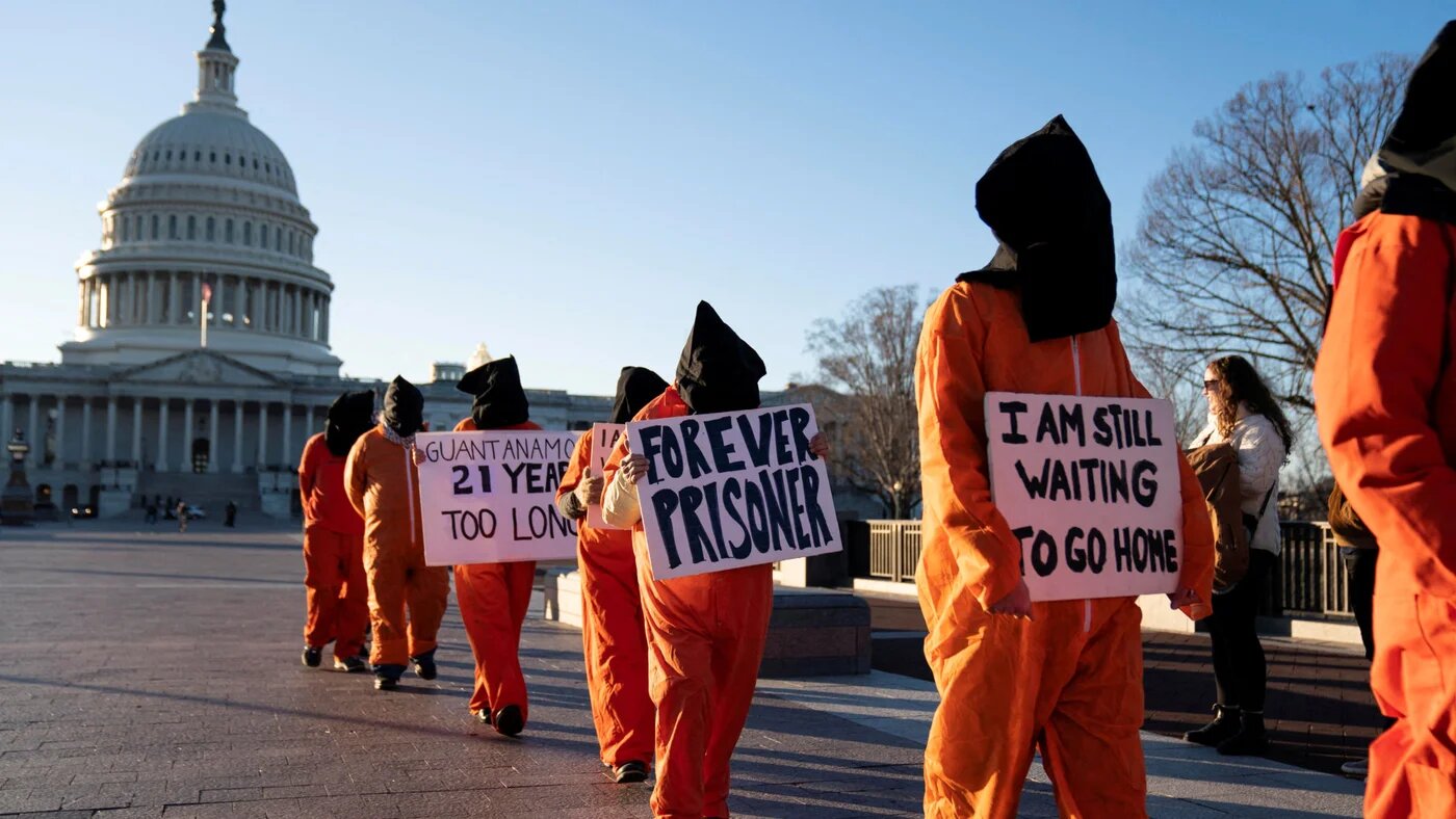 A group of activists dressed as prisoners protest against the Guantanamo Bay detention camp outside the Capitol in Washington on 9 January 2023 (Sarah Silbiger/Reuters)
