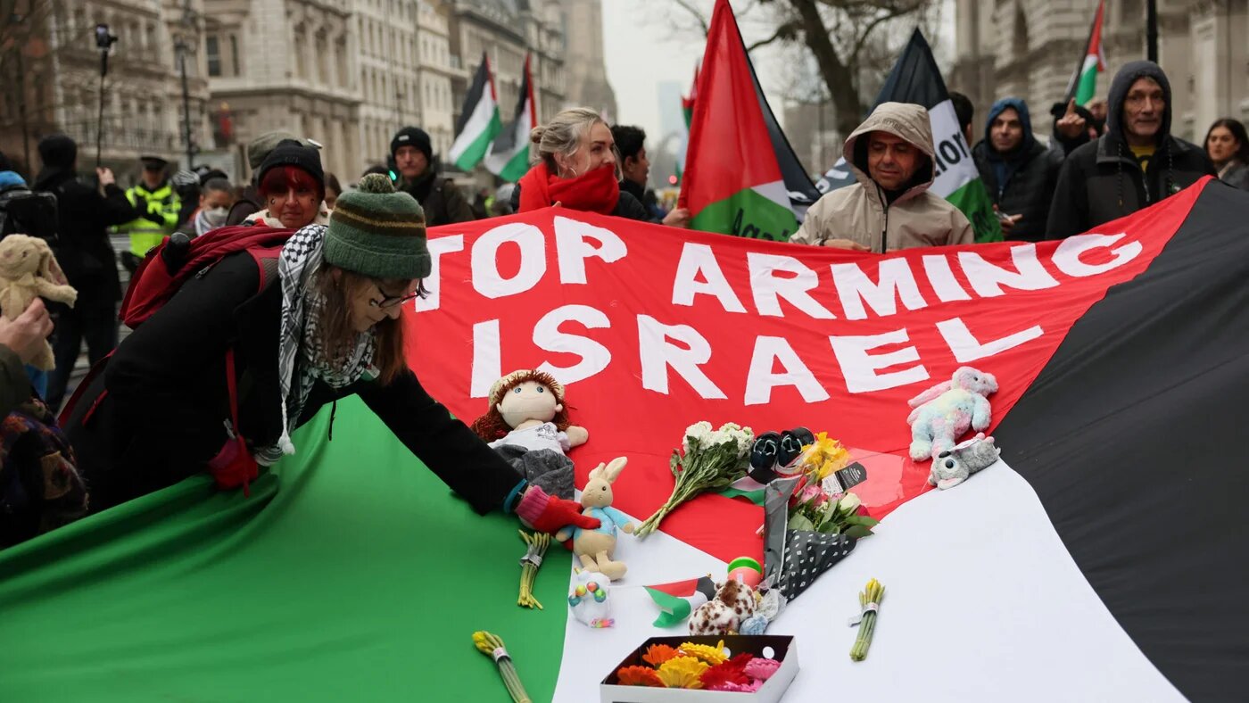 Protesters hold a flag during a demonstration in support of Palestinians in Gaza, following a ceasefire agreement between Israel and Hamas, in London on 18 January 2025 (Isabel Infantes/Reuters)