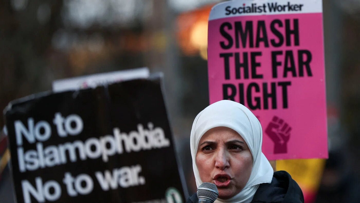 A demonstrator holds a sign reading 'No to Islamophobia' during a protest outside a Reform UK rally in Birmingham, UK on 28 March 2025 (Sodiq Adelakun/Reuters)