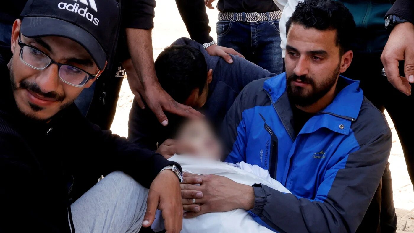 Osama Miqdad reacts holding the body of his nephew, Abd al-Rahman Miqdad,m three, who was killed in Israeli strikes, at Nasser hospital, in Khan Younis, 31 March 2025 (Reuters/Hatem Khaled)