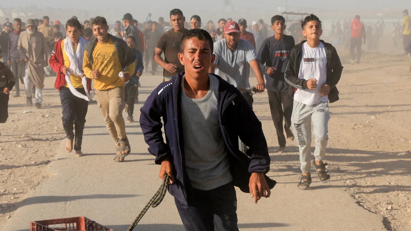 Palestinians walk to collect aid supplies from the US-backed Gaza Humanitarian Foundation, in Khan Younis, in the southern Gaza Strip, 29 May 2025 (Reuters/Hatem Khaled)