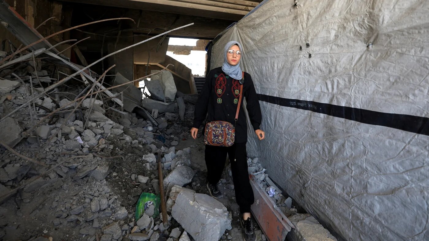 A Palestinian woman walks through the destroyed Islamic University of Gaza, where she has taken shelter, in Gaza City, on 1 June 2025. (Dawoud Abu Alkas/Reuters)