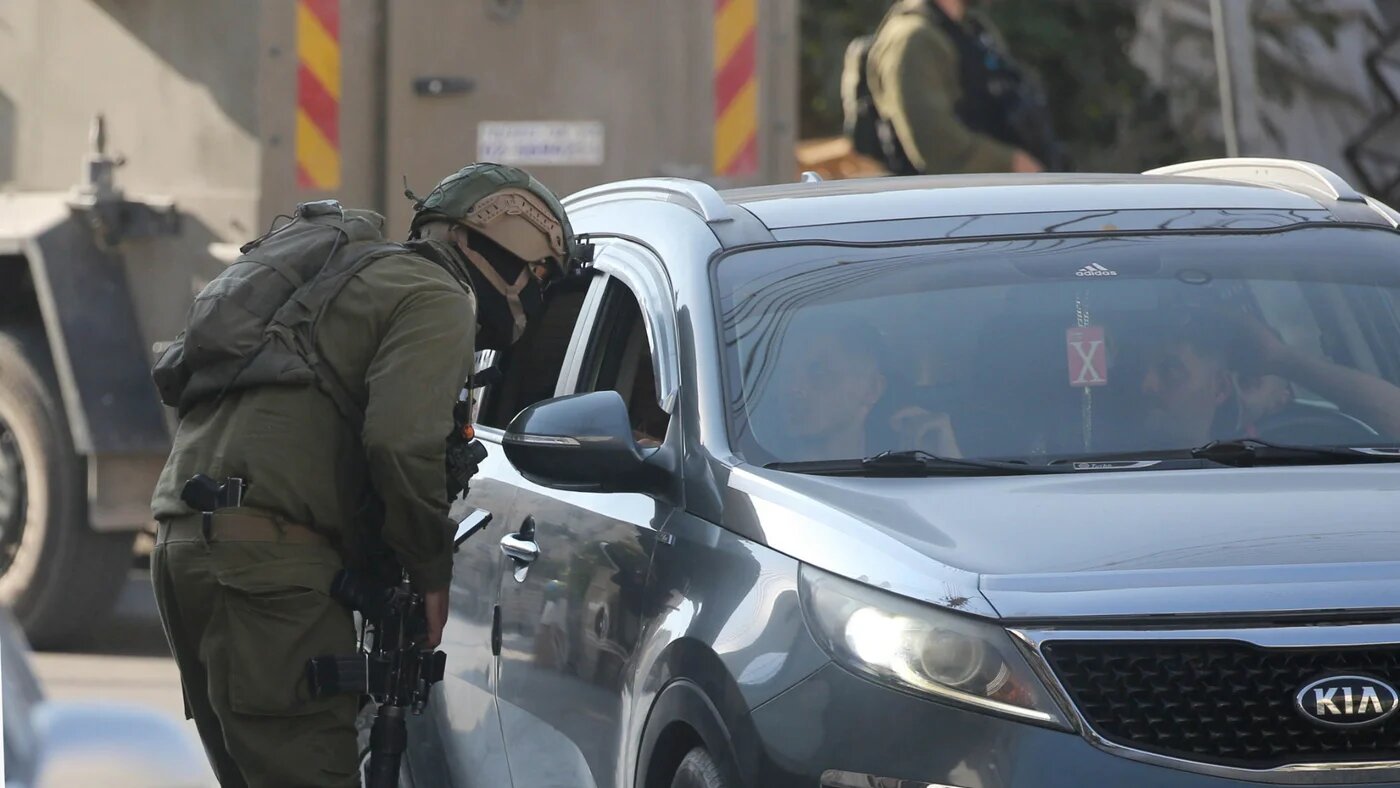 An Israeli soldier stops a Palestinian driver during a raid at the entrance to the Old City of Nablus in the West Bank on 17 September 2025 (Nasser Ishtayeh/SOPA Images via Reuters)