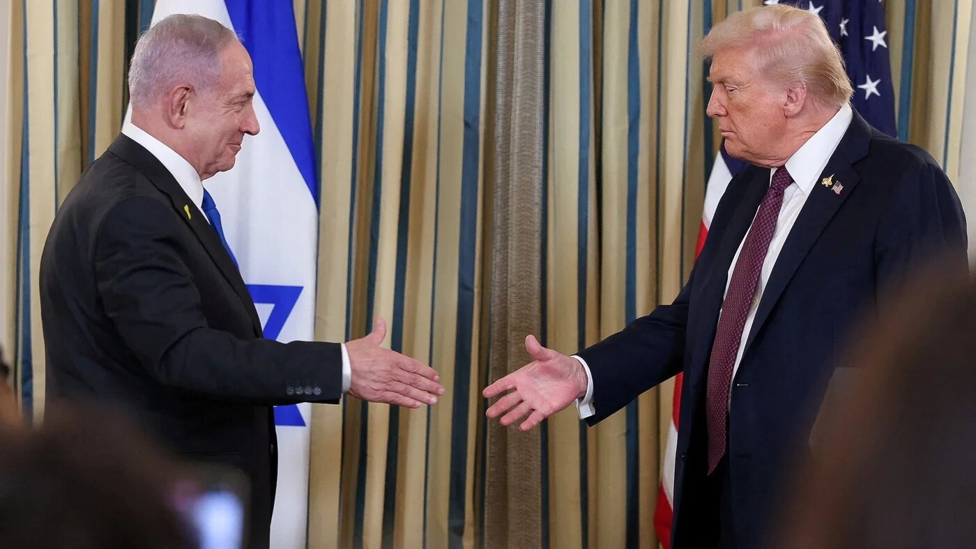 US President Donald Trump and Israeli Prime Minister Benjamin Netanyahu reach to shake hands at a joint press conference in Washington, on 29 September 2025 (Jonathan Ernst/Reuters)