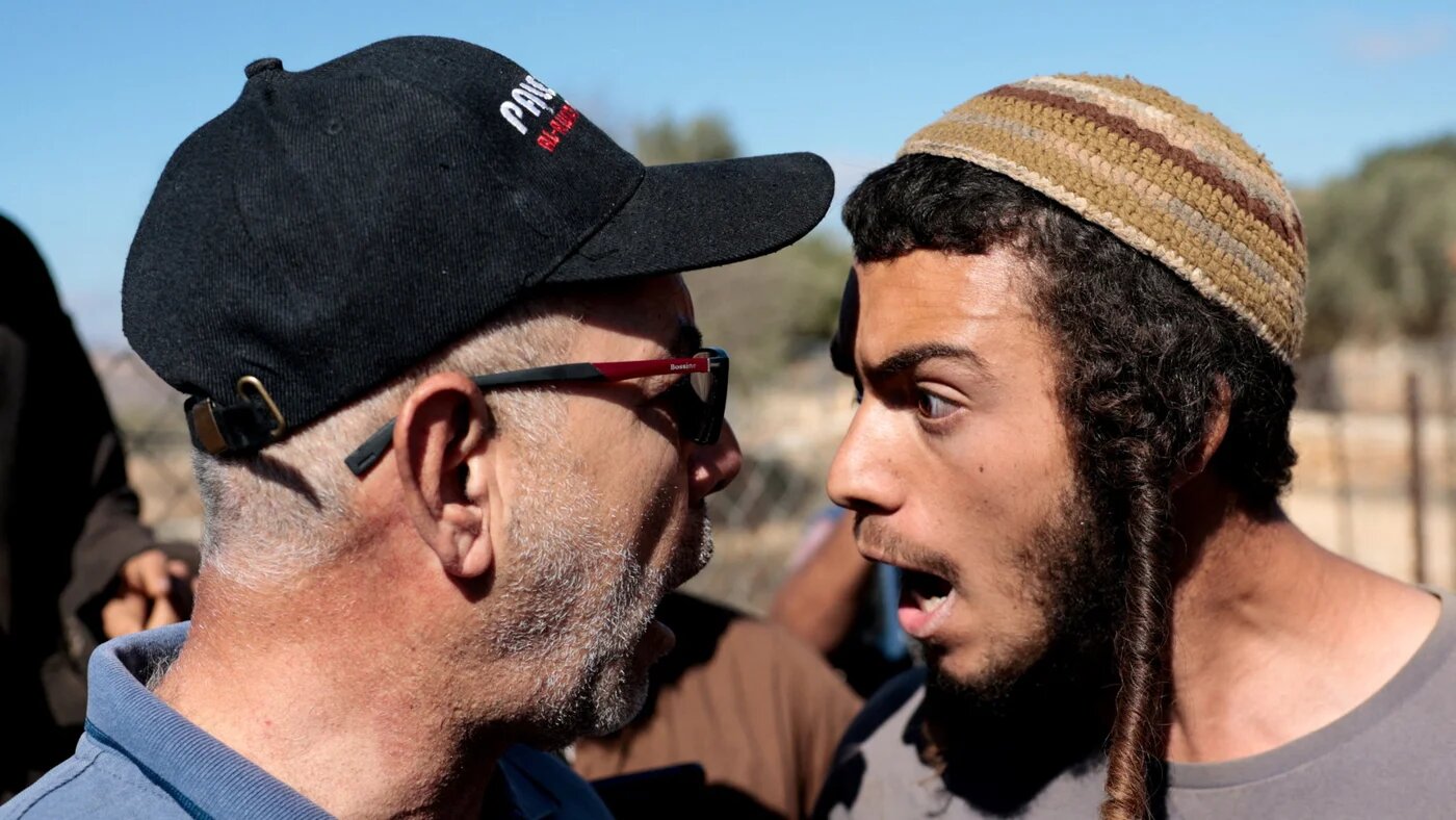 An Israeli settler argues with a Palestinian farmer, during olive harvesting in Silwad, near Ramallah, in the occupied West Bank, 29 October2025 (Reuters/Mohammed Torokman)
