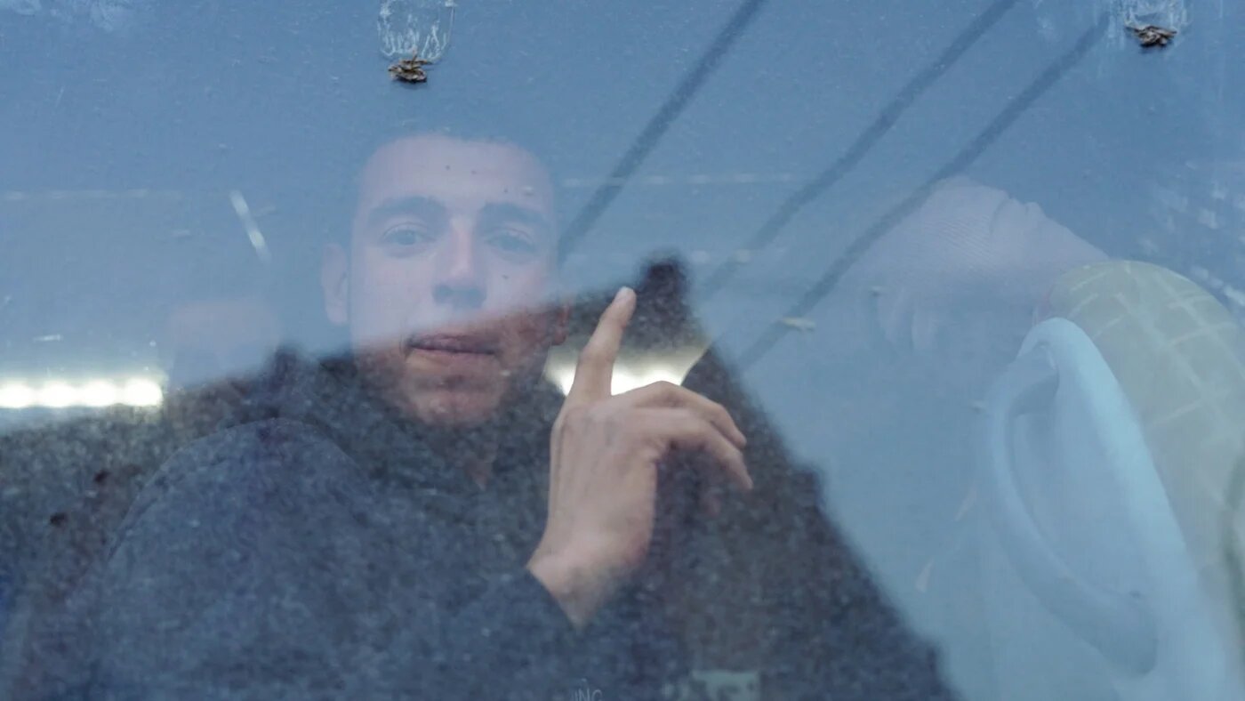 A former detainee gestures while looking through a window after being set free from al-Aqtan prison following its takeover by the Syrian government in Raqqa, Syria, 24 January 2026 (Reuters/Karam al-Masri)