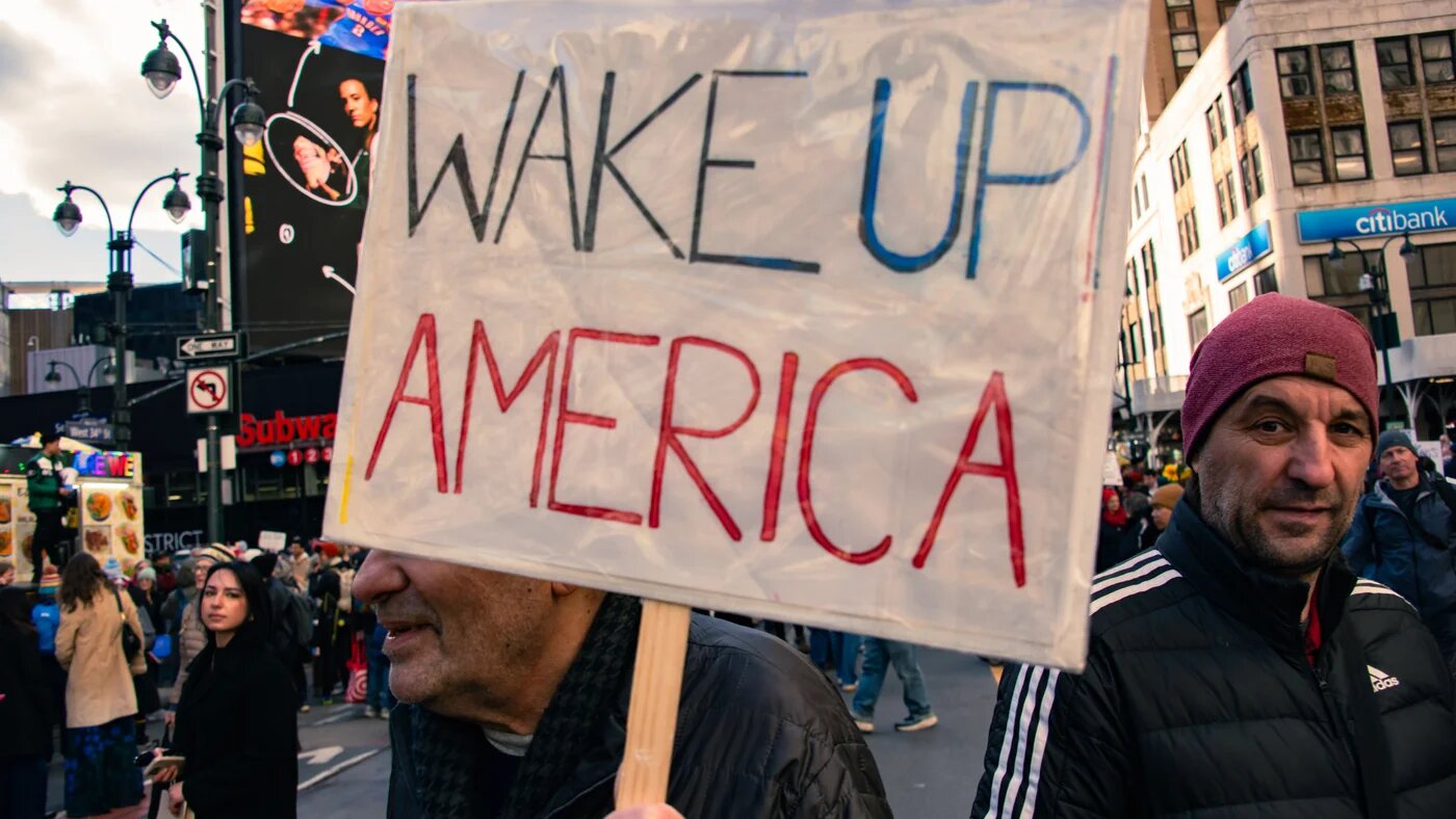 A demonstrator holds a sign during a protest against the Trump administration in New York, United States, 28 March 2026 (Neil Constantine/NurPhoto)
