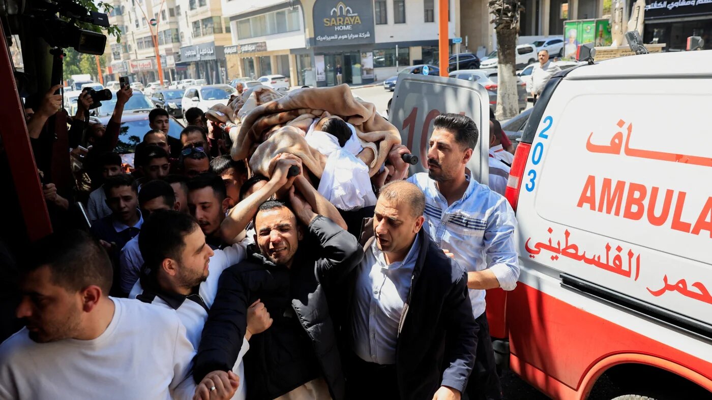 Mourners carry the body of 16-year-old Palestinian Ibraheem Khayyat, who was killed in an Israeli raid, during his funeral in Hebron, on 30 April 2026 (Mussa Qawasma/Reuters)