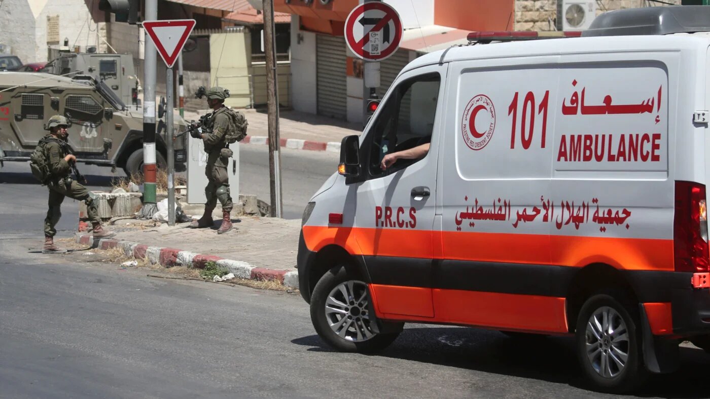 A Palestinian ambulance is seen in front of Israeli soldiers during a military raid in the Rafidia neighbourhood of Nablus, in the occupied West Bank, on 12 July 2026 (Nasser Ishtayeh/SOPA Images via Reuters)