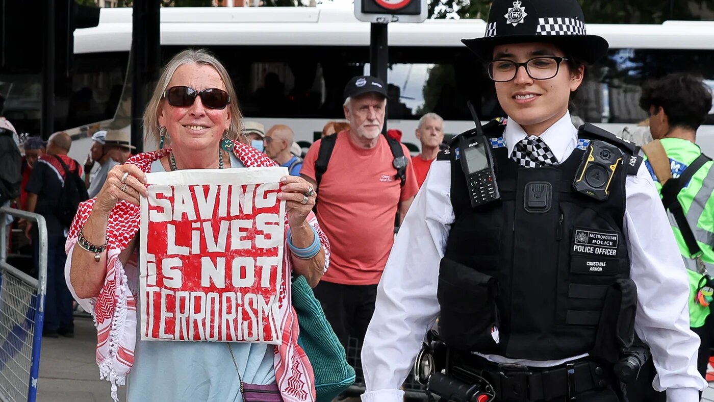 A police officer detains a Palestine Action supporter during a Defend Our Juries protest outside Westminster Magistrates' Court in London on 30 July 2026