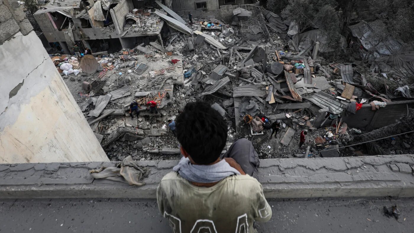 Palestinians inspect belongings amid rubble after an Israeli airstrike hit a residential block in al-Zawayda, central Gaza, on 11 October 2026 (Moiz Salhi/APAimages via Reuters)