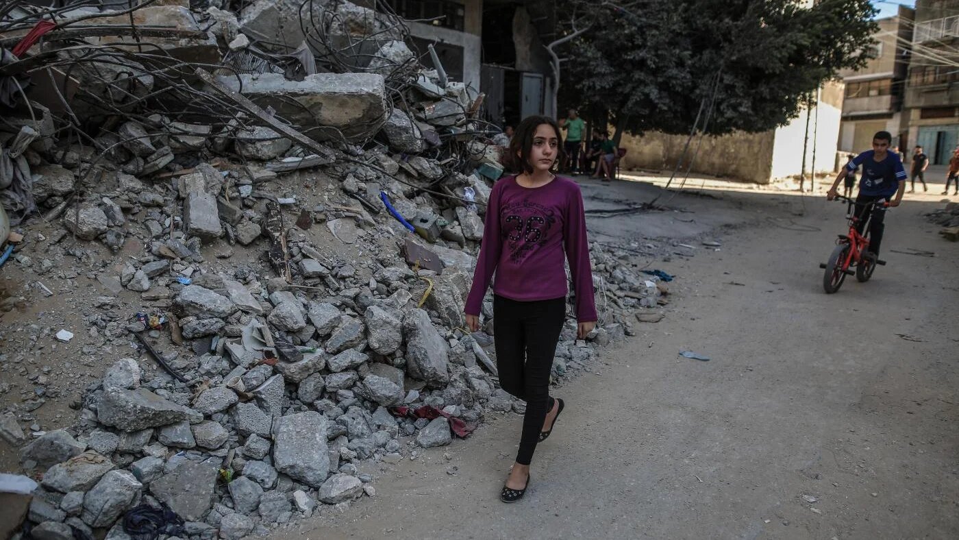 Nadine Abdel-Taif marche dans son quartier, où de nombreux bâtiments ont été détruits, le 20 mai 2021 (MEE/Sanad Latefa)
