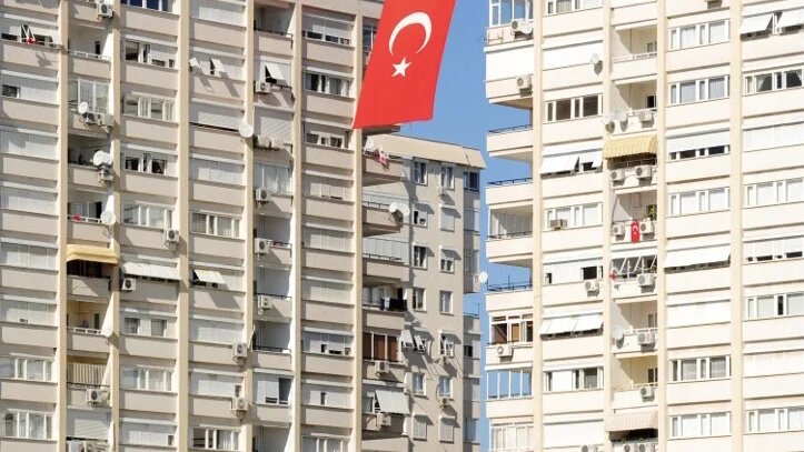 A Turkish flag flutters between apartment blocks in Antalya (File photo/AFP)