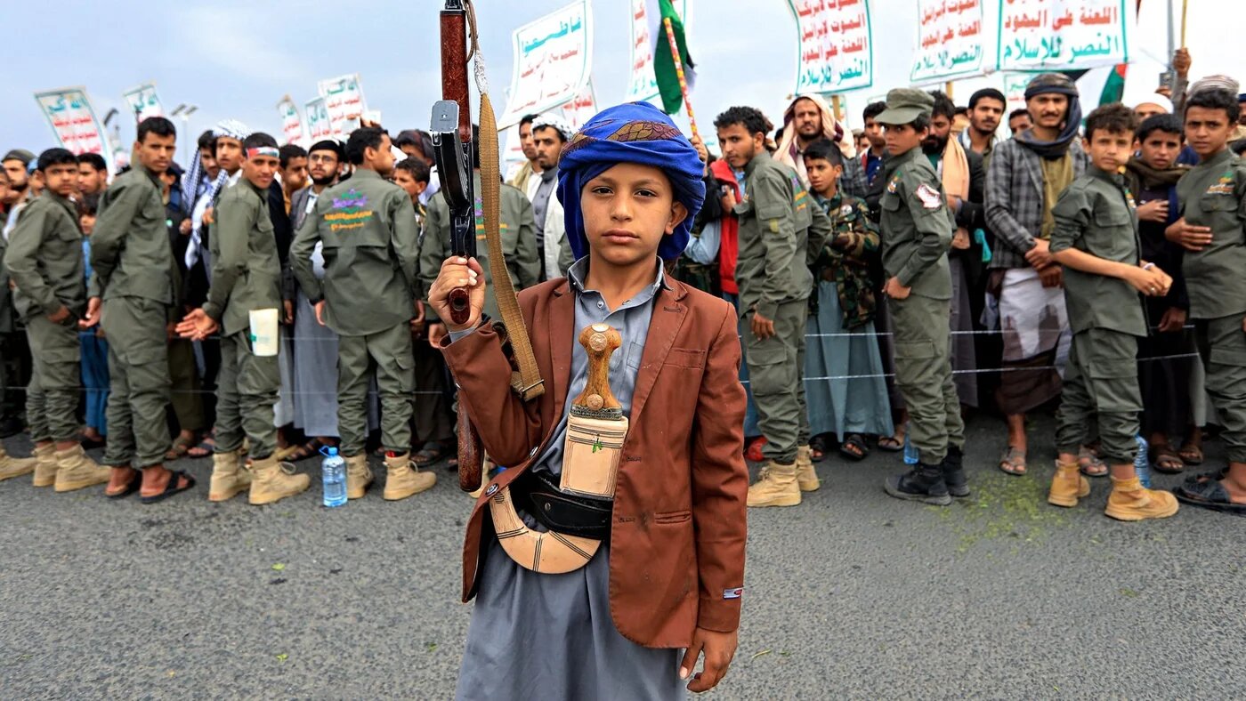 A Yemeni boy carries a rifle during a Palestine solidarity rally in Sanaa, 12 July 2024 (Mohammed Huwais/AFP)