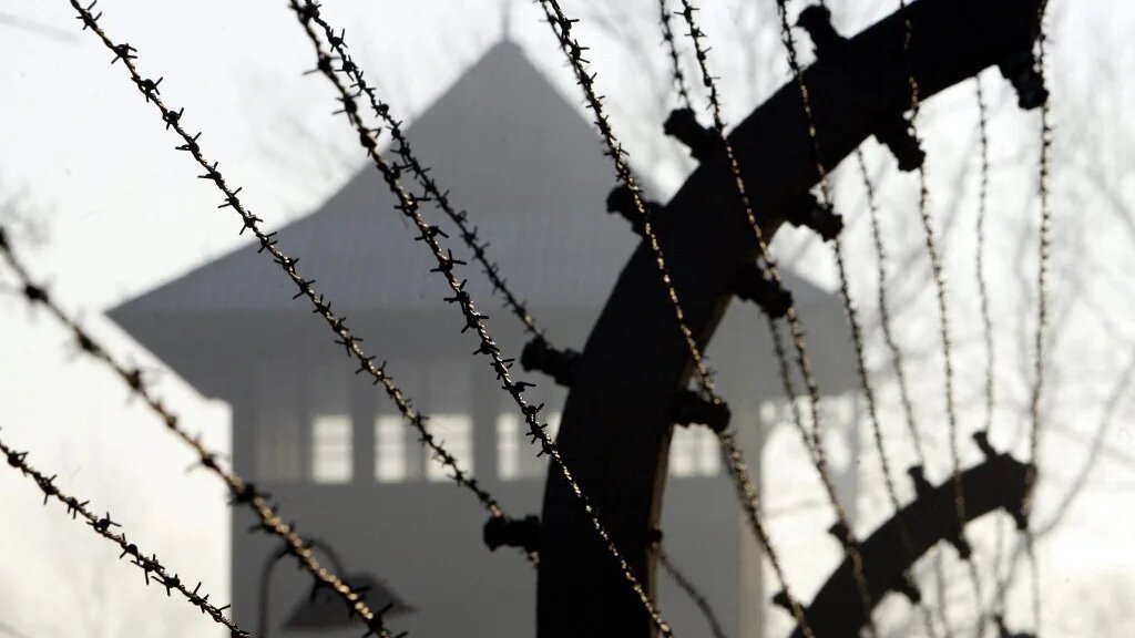A barbed wire fence and watch tower at Auschwitz concentration camp, 12 January 2005 (AFP)